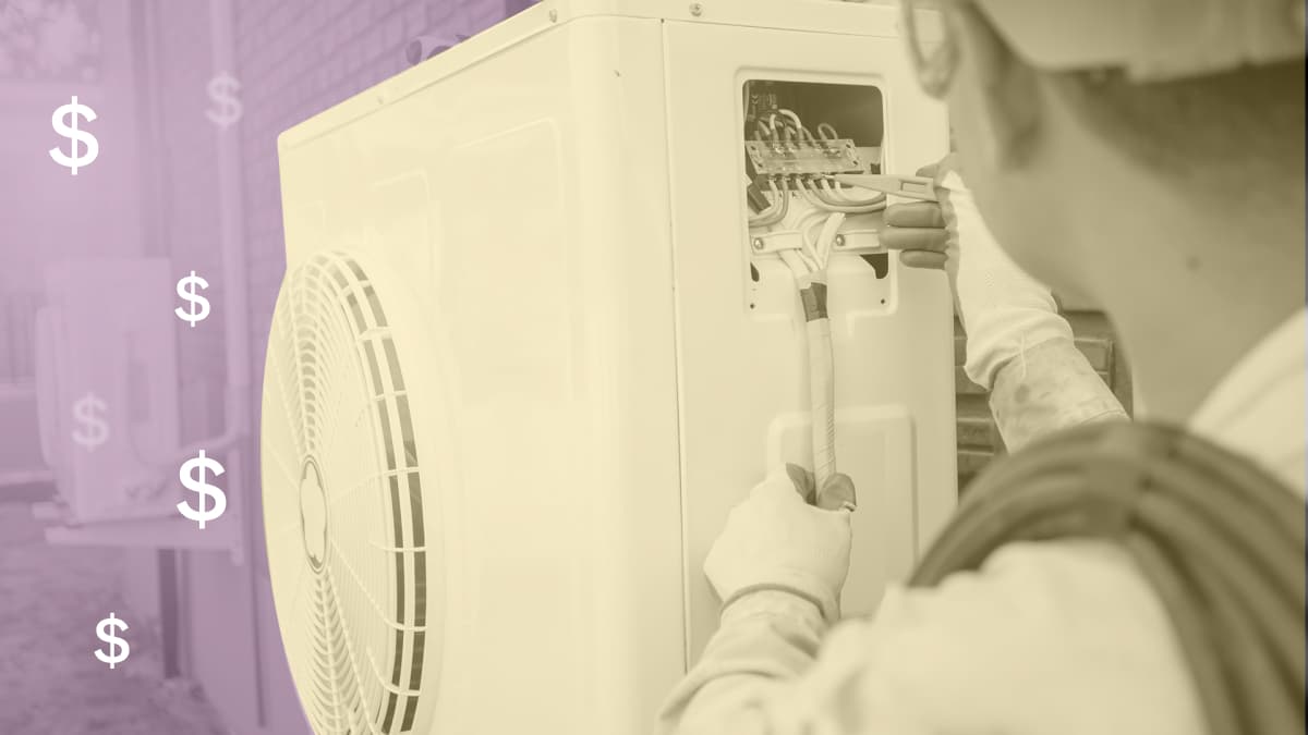 A close up photo of a heat pump technician working on a heat pump on the outside of a house
